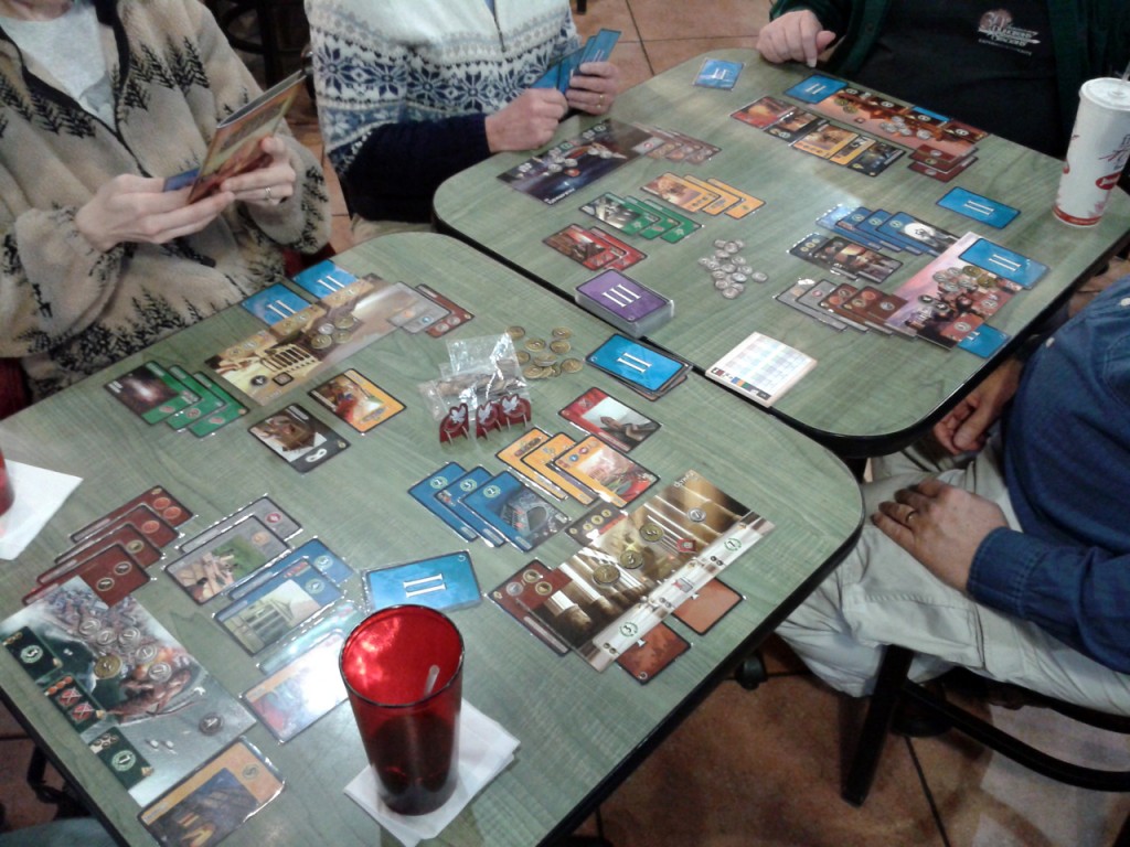 A six-player game of 7 Wonders with the Cities expansion included. Players have their Wonder in front of them, with the cards played around it representing their cities as they develop.